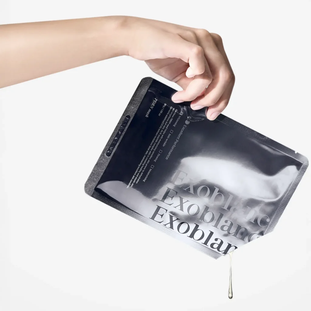 Hand holding the Exoblanc PDRN bio-cellulose mask